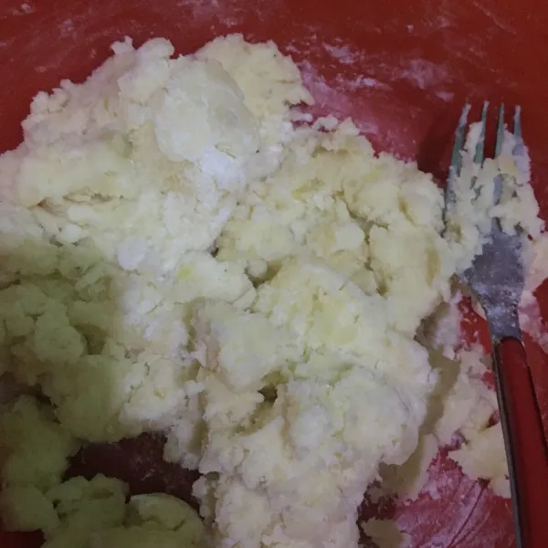 Pindahkan kentang ke wadah, tambahkan gula pasir dan garam lalu lumatkan menggunakan garpu. Tambahkan tepung. Aduk rata.