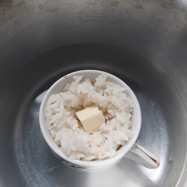 Tambahkan nasi yang sudah setengah matang dan beri keju.