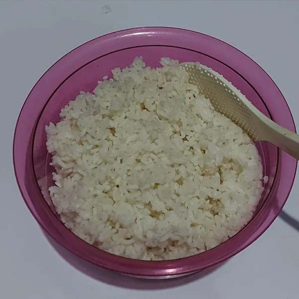 Cuci bersih beras, lalu tambahkan air sebuku jari. Masukkan ke rice cooker, masak sampai matang.