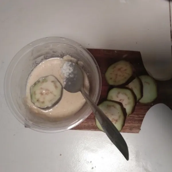 Iris tipis terong. Masukkan ke dalam adonan tepung beras yang telah ditambahkan air, garam, gula dan juga kaldu jamur.