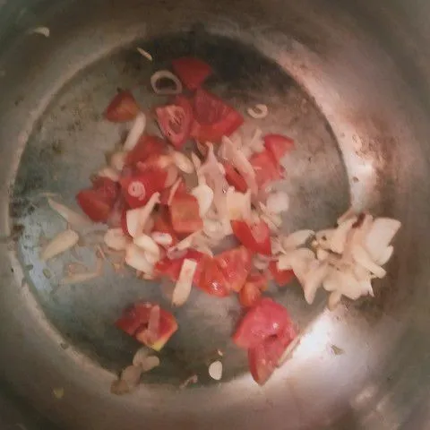 Masukan bawang putih, bawang merah, laja. Setelah tercium baunya masukkan tomat