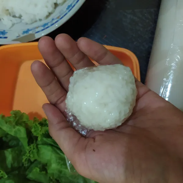Kepal-kepal nasi menggunakan plastik wrap, bentuk untuk telinga dan wajah.
