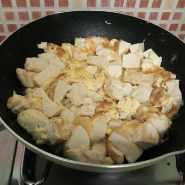 Kocok telur dengan sedikit garam dan lada bubuk. Masukkan tahu, goreng sampai kecoklatan