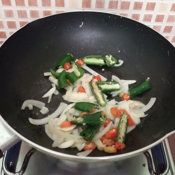 Masukkan cabai hijau dan rawit, tumis sampai layu