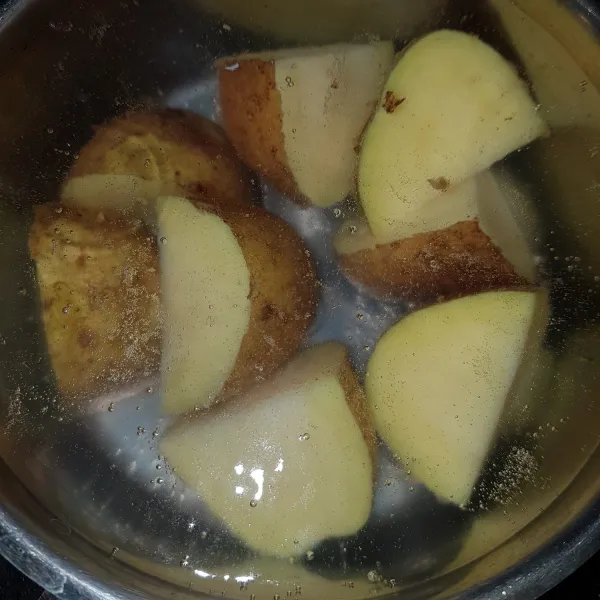 Rebus kentang hingga empuk, angkat dan tiriskan dan kupas kulitnya.