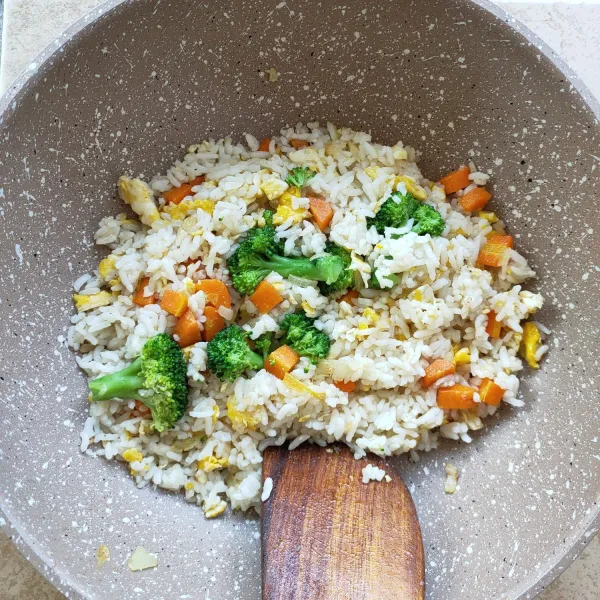 Masukkan nasi, aduk-aduk sampai tercampur rata, lalu masukkan brokoli. Aduk-aduk sebentar saja.