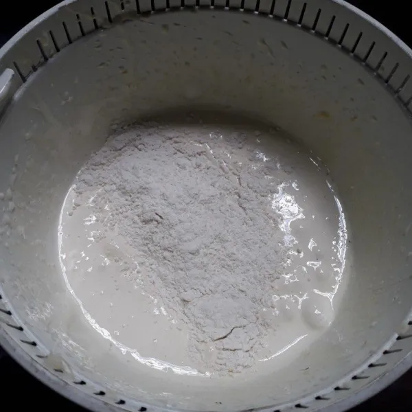 Masukkan bahan kering dan air secara bertahap, aduk balik dengan spatula.