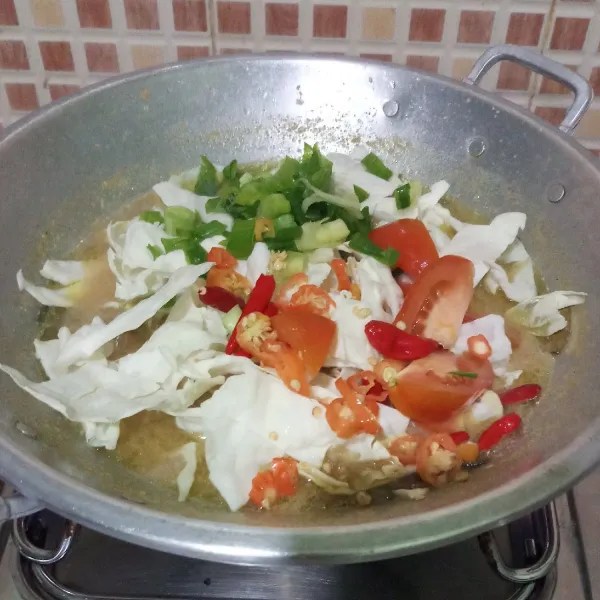 Masukkan kol, daun bawang, tomat dan cabe, masak sampai mendidih. Koreksi rasa, matikan api dan siap disajikan.