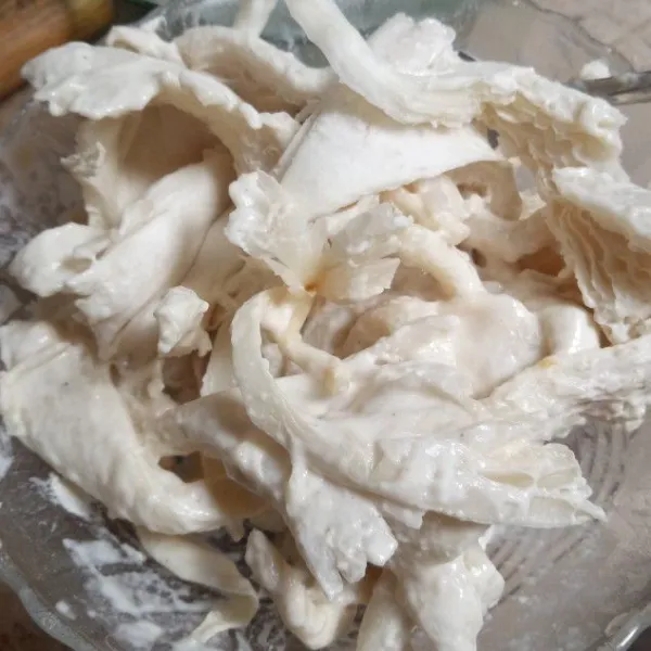 Masukkan suwiran jamur tiram ke dalam campuran tepung basah. Baluti hingga rata.