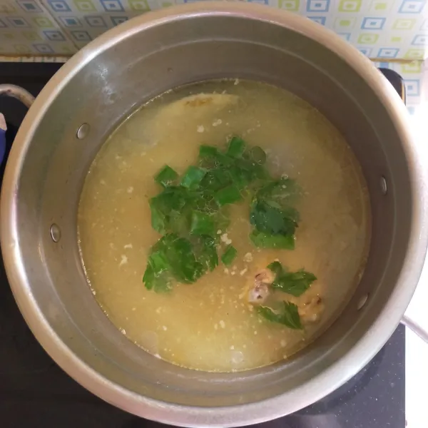 Tambahkan daun bawang dan daun seledri, lalu matikan api.