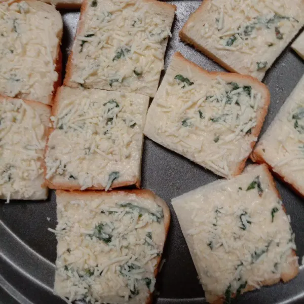 Olesi tiap lembar roti tawar dengan adonan cream cheese lalu taburi dengan keju parut.