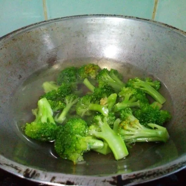 Brokoli dipotong perkuntum, cuci dengan air garam, bilas bersih, lalu rebus selama 2 menit. Guyur dengan air dingin untuk menghentikan efek panas sehingga warna tetap hijau.