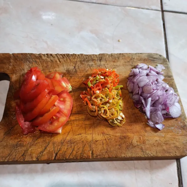 Iris bawang merah dan cabai. Potong tomat.