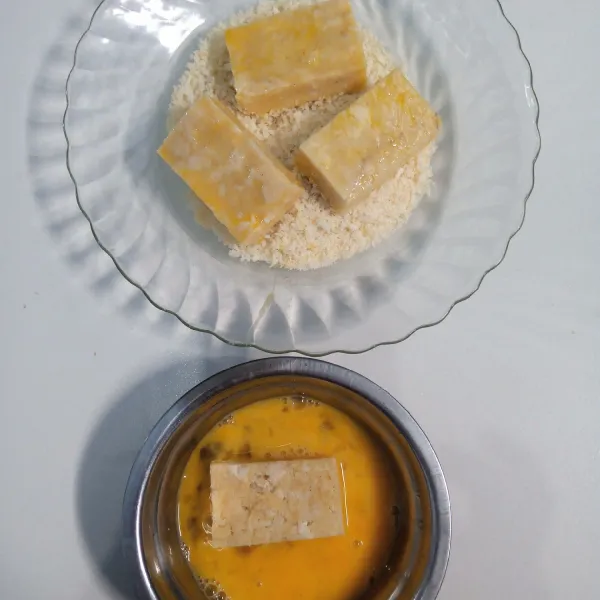 Potong-potong adonan. Celupkan kedalam kocokan telur. Kemudian gulingkan ke dalam tepung roti/panir.