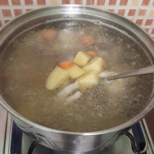 Masukkan kentang dan wortel, rebus sampai matang.