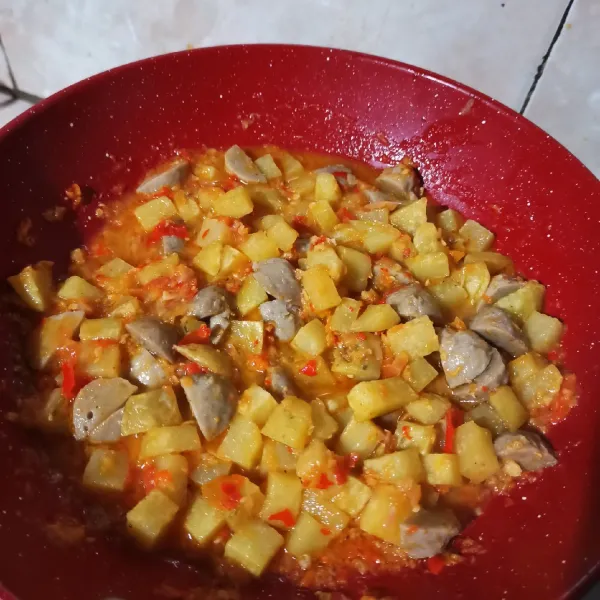 Tambahkaan kentang, penyedap rasa, dan lada bubuk. Tunggu hingga bumbu agak kering, lalu angkat.