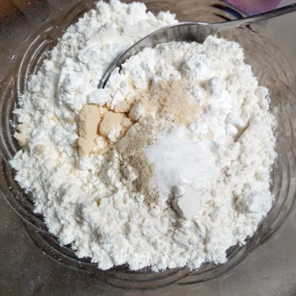 Masukkan tepung terigu dalam mangkuk, tambahkan tepung maizena, bawang putih bubuk, merica bubuk, garam halus dan kaldu bubuk. Aduk rata.