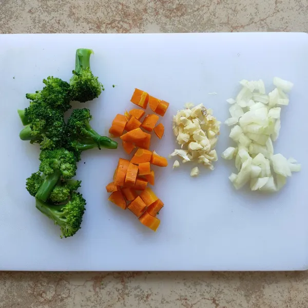 Brokoli dipotong per kuntum, lalu direbus sampai empuk. Wortel direbus sampai matang, lalu dipotong dadu.