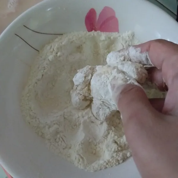 ambil ayam balurkan di tepung bumbu kering hingga rata, lakukan dua kali pelapisan. setelah itu goreng di minyak panas hingga kuning kecoklatan.