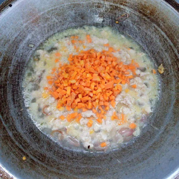 Tambahkan air. Aduk rata. Masak sampai mendidih. Kemudian masukkan wortel. Masak sampai wortel layu.