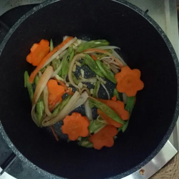 Oseng bawang putih lalu masukan sayuran dan crab stick, beri sejumput garam, oseng hingga matang.