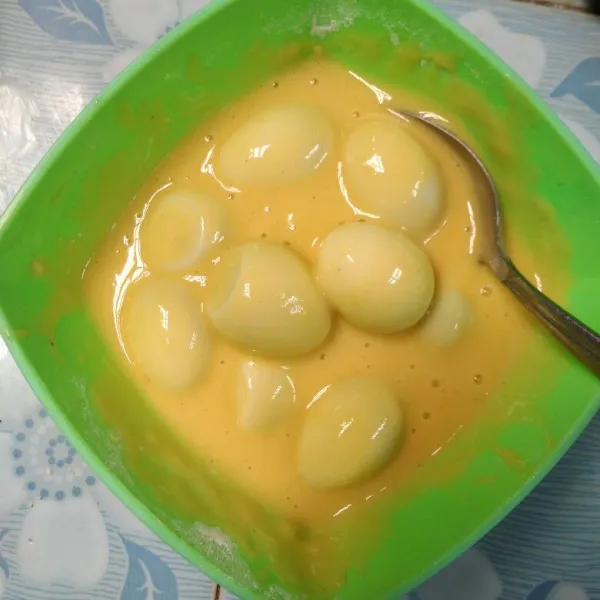 Masukkan telur puyuh, balur rata, kemudian gulingkan diatas tepung panir.