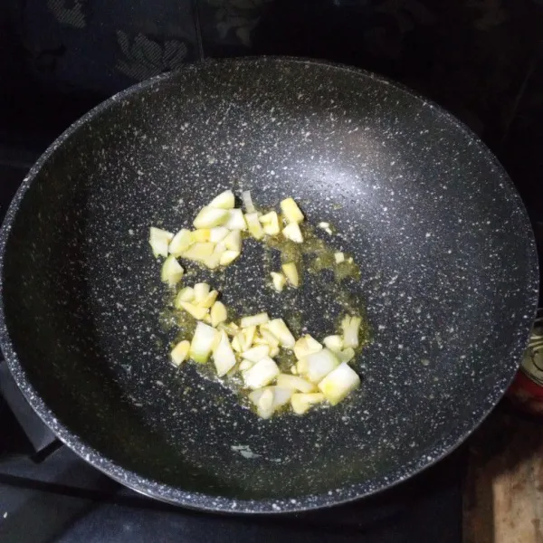 Buat nasi gorengnya, panaskan mentega, tumis bawang putih dan bawang bombay sampai layu.