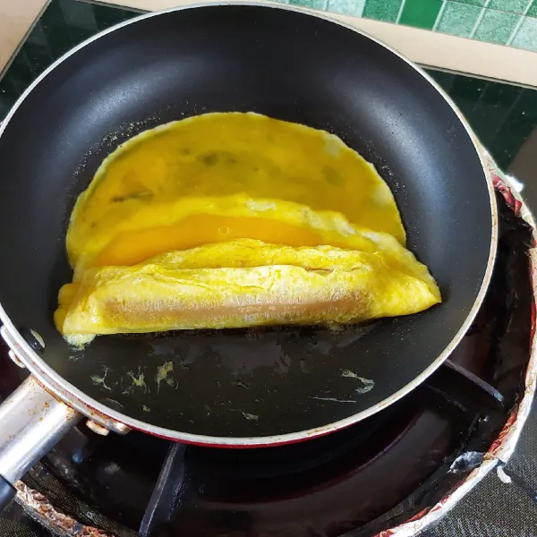 Geser telur dadar. Tuangi telur kocok di bagian ujung. Tunggu sebentar lalu gulung. Angkat dan potong-potong.