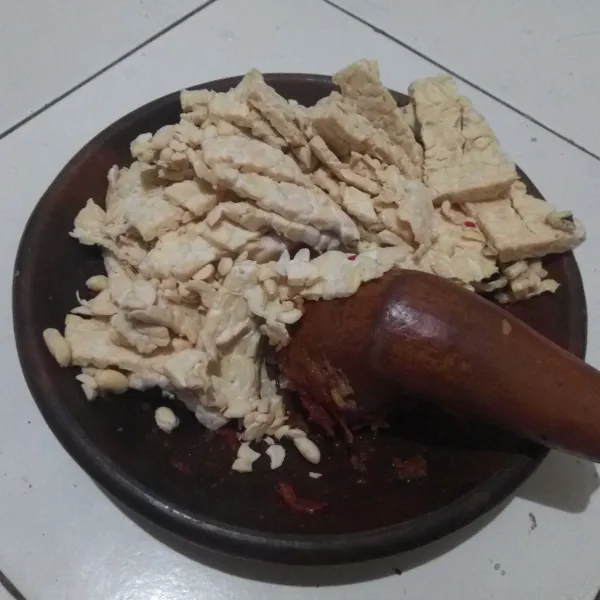 Cacah tempe, masukkan ke dalam cobek, lalu ulek bersama bumbu halus.