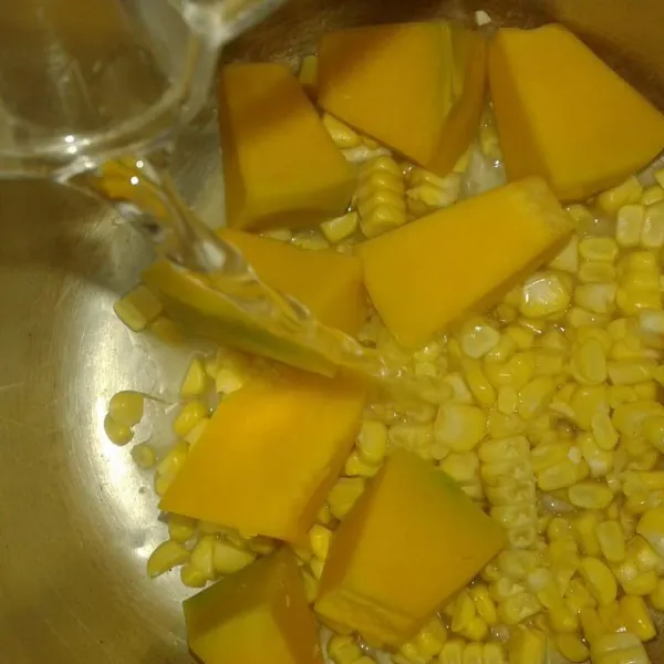 Dalam panci campur labu kuning, jagung manis dan kaldu ayam.