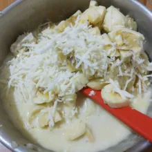 Masukkan potongan pisang dan keju parut, aduk rata. Sisakan sebagian keju parut untuk taburan.
