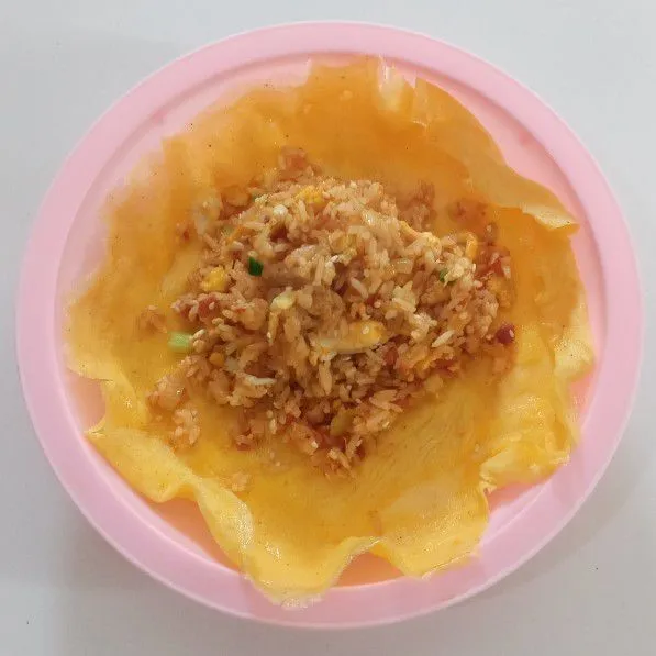 Tuang nasi di atas dadar lalu lipat seperti membuat amplop.