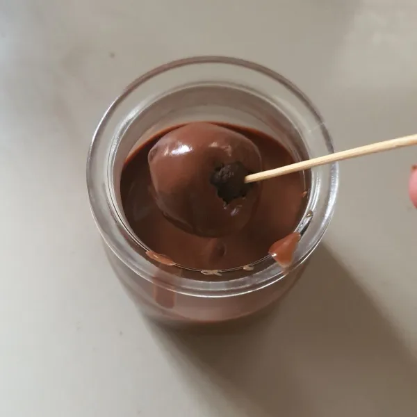 Lelehkan coklat bersama 1 sdm mentega. Masukkan ke dalam gelas. Celupkan adonan satu persatu ke dalam coklat cair.