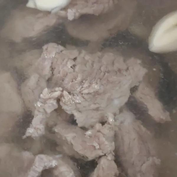 Rebus daging dengan bawang putih dan garam sampai empuk. Tiriskan. Air bekas rebusan jangam dibuang ya.