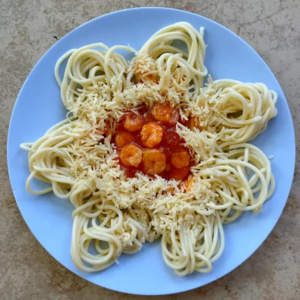 Sajikan spaghetti bersama udang asam manis dan keju parut.