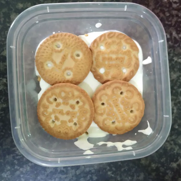 Beri kepingan biskuit diatas whipped cream