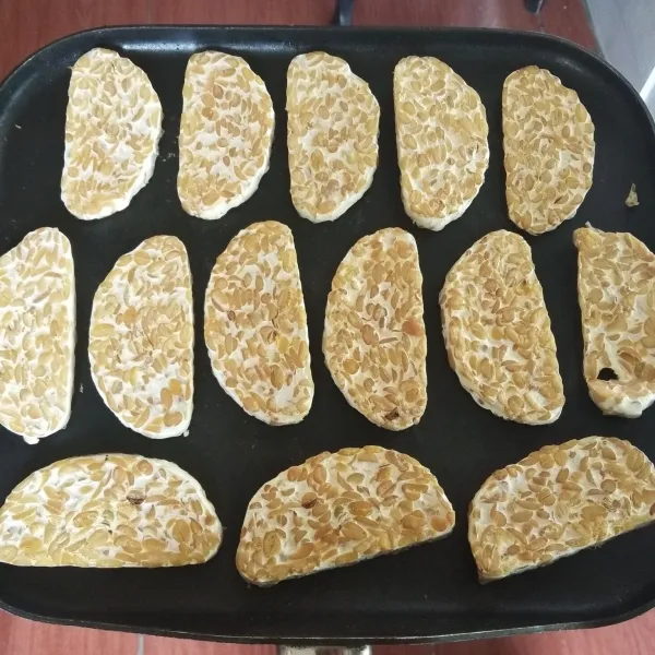 Iris tempe menjadi beberapa bagian. Panggang di atas teflon sampai kedua sisinya mengering. Angkat.