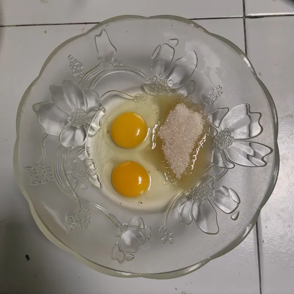 Siapkan wadah, masukkan telur dan gula putih. Aduk merata (bisa dengan garpu).