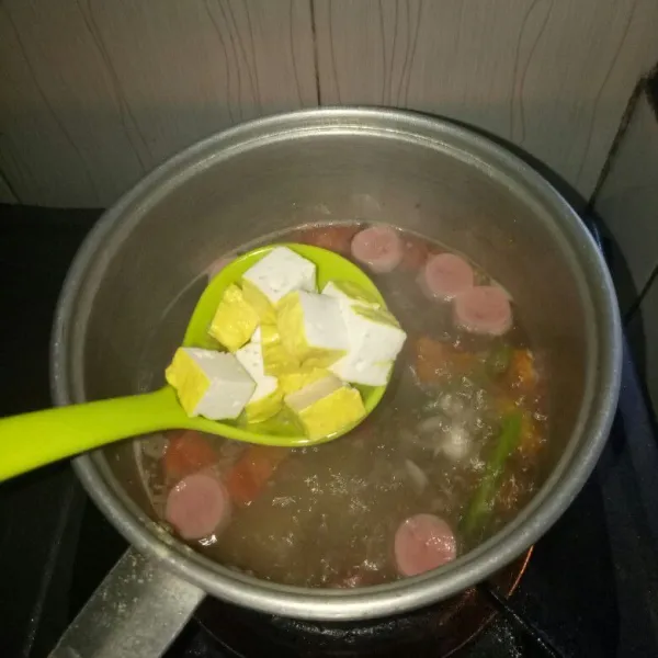 Potong dadu tahu,lalu masukan ke panci kuah.Aduk rata,masak sampai air kuah mendidih kembali.