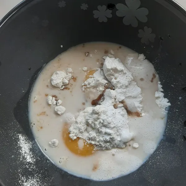 Campurkan tepung terigu, kuning telur, ekstrak vanila, dan baking powder. Aduk adonan dengan spatula hingga rata.