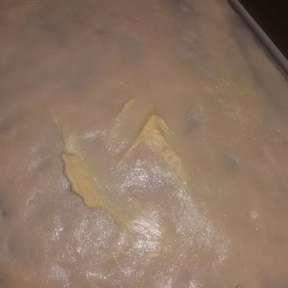 Setelah 60 menit, ambil 1 buah adonan lalu pipihkan/lebarkan hingga tipis. Lalu olesi dengan mentega seluruh permukaan  adonan.