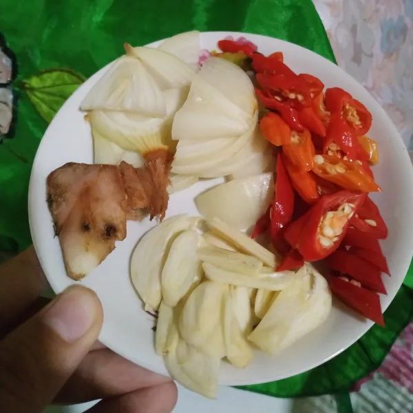 Siapkan bumbu yang akan ditumis yaitu lengkuas, bawang putih iris, bawang bombai iris, cabai rawit, dan cabai merah.