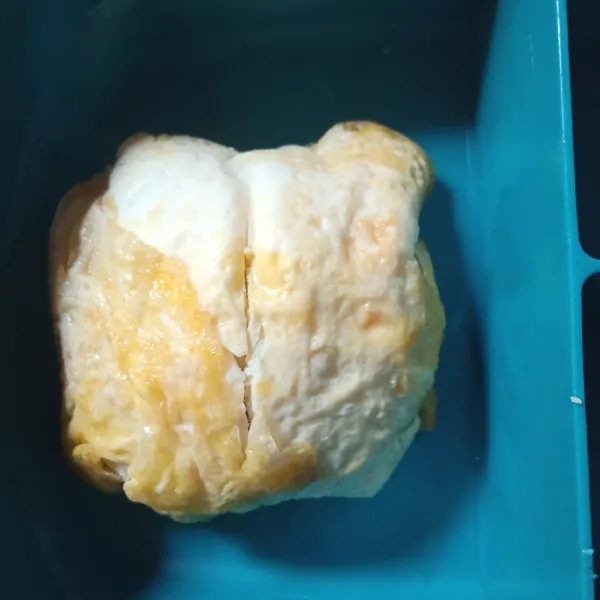 Taruh tempat bekal di atas mangkok, lalu balik. Gunting bagian tengah lalu bentuk seperti kelopak bunga. Tambahkan irisan tomat, kol rebus ,selada dan susu uht. Bekal siap dibawa anak.