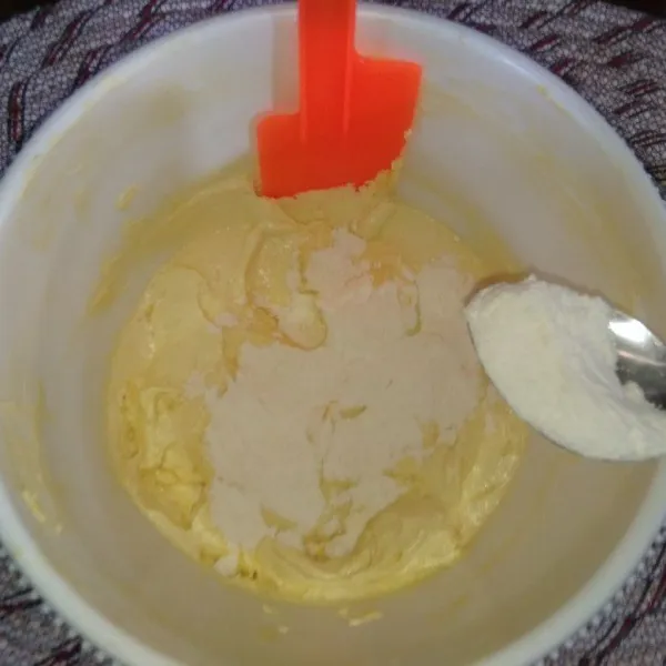 Tambahkan essence jeruk secukupnya, aduk rata, kemudian tambahkan terigu sedikit demi sedikit sambil diaduk dengan spatula hingga merata