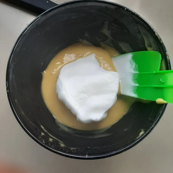 Campurkan sedikit adonan putih telur ke dalam adonan kuning telur. Kemudian aduk adonan dengan spatula dengan teknik aduk satu putaran.