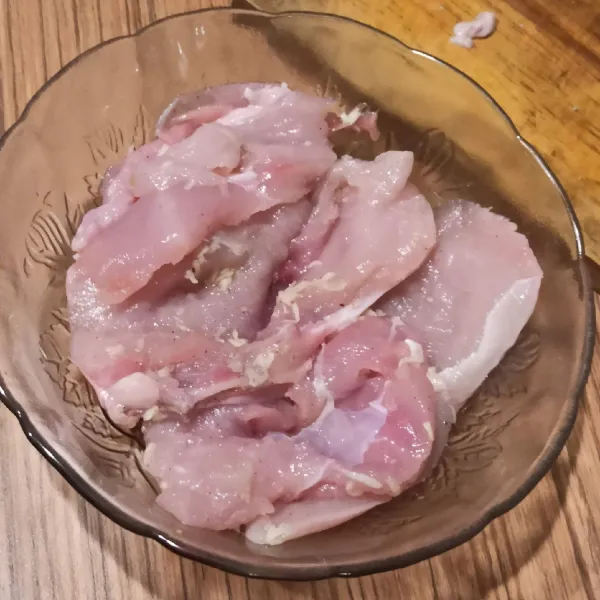 Marinasi ayam selama 15 menit dengan garam, merica, dan bawang putih yang diparut.
