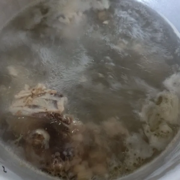 Siapkan panci, rebus air bersama dengan sisa tulang ayam. Ini untuk kaldu supaya gurih. Masukkan bumbu halus.