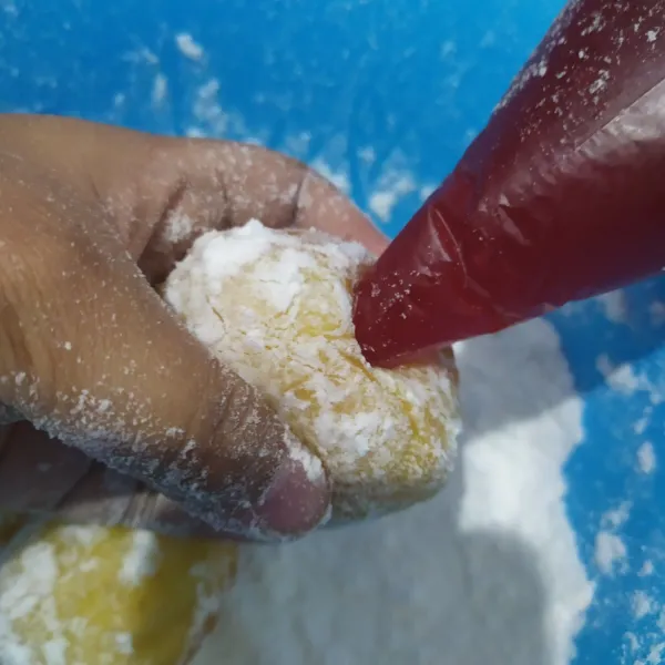 Beri filling selai strawberry, lakukan pada semua donat kemudian sajikan.