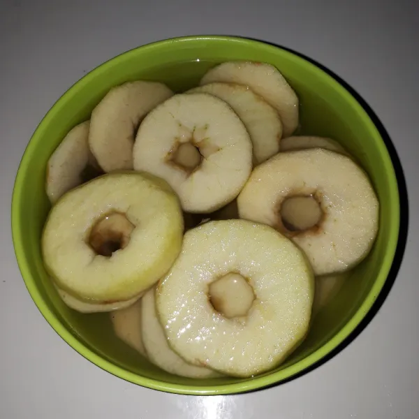 Kupas apel, potong bentuk lingkaran lalu buang bagian bijinya. Cuci bersih lalu rendam dengan 400 ml air dan 1/2 sdm garam selama 10 menit lalu tiriskan.