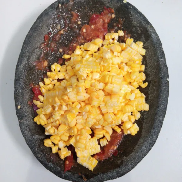 Tambahkan jagung. Kemudian ulek kasar.